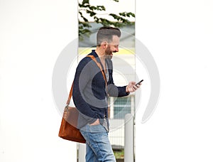 Happy mature man on the city street using cell phone