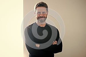 Happy mature man with grey beard hair smile with confidence indoors, unshaven