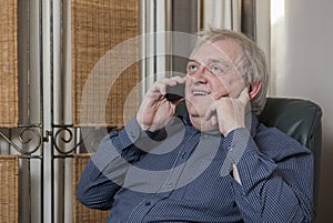 Happy mature man laughing and talking on the phone