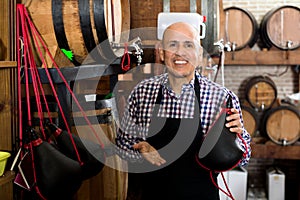 Seller holding spanish bota bag for wine photo