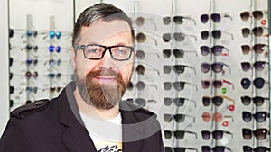 Happy mature man showing thumbs up at the eyewear store