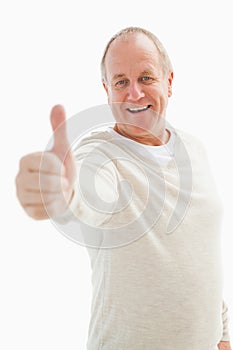 Happy mature man showing thumbs up to camera