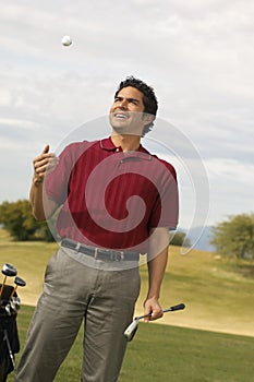 Happy Mature Man Tossing Golf Ball