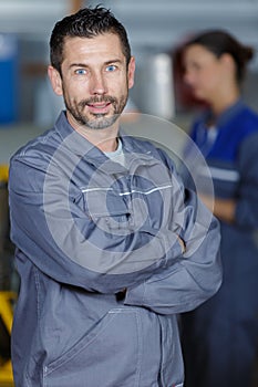 happy mature mechanic with armscrossed photo