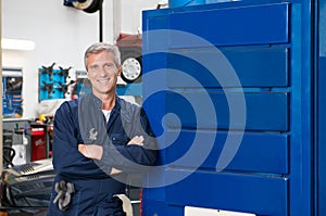 Happy Mature Mechanic In Garage