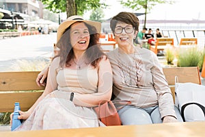 Happy mature mother and her adult daughter enjoying in conversation while spending Mother& x27;s day together in a cafe