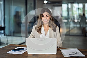 Happy mature professional business woman with laptop in office, portrait.