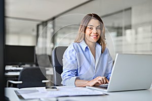 Happy mature professional business woman with laptop in office, portrait.