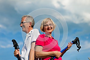 Happy mature or senior couple doing Nordic walking