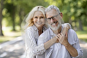 Happy Mature Spouses. Portrait of older couple hugging and smiling at camera