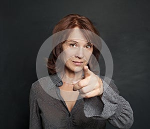 Happy mature woman businesswoman pointing on blackboard