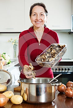 Happy mature woman cooking lent diet soup