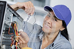 Happy mature woman fixing computer