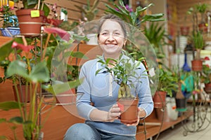 Happy mature woman in flower store