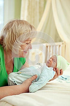 Happy mature woman holding her newborn grandson photo