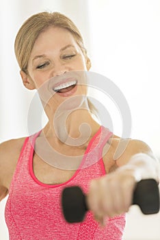 Happy Mature Woman Lifting Dumbbell At Home