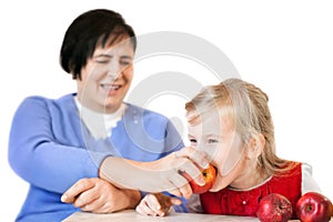 Happy mature woman and little girl with apples