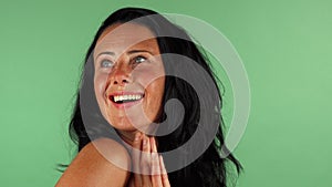 Happy mature woman looking surprised on green chromakey
