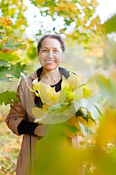 Happy mature woman with maple posy