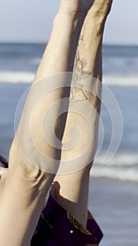 happy mature woman raising hands up in the air and open arms to sky by the ocean