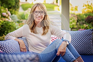 Happy mature woman relaxing at home in the backyard