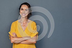 Happy mature woman smiling on grey wall