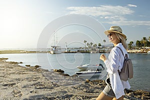 Happy mature woman walking along harbor Of Side, Turkey.