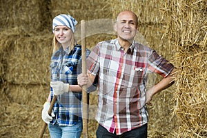 Happy mature and young farmers in hayloft