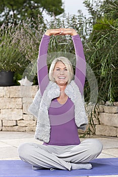 Happy matured woman doing yoga