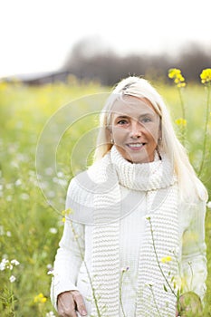 Happy matured woman in flowerfield