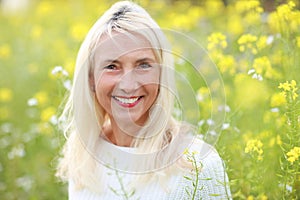 Happy matured woman in flowerfield