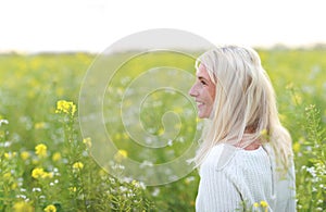 Happy matured woman in flowerfield