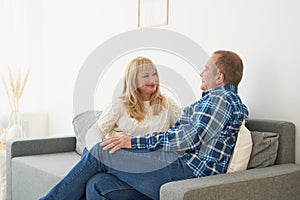 Happy meddle age couple at home. Handsome mature man and attractive woman talking
