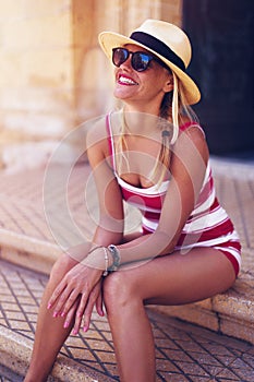 Happy mediterranean woman in hat and sunglasses toothy smile