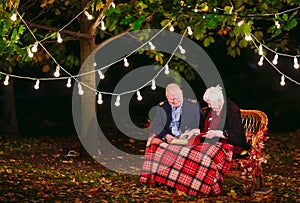 Happy memories. Happy senior couple sitting on sofa watching album with photos