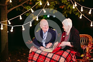 Happy memories. Happy senior couple sitting on sofa watching album with photos