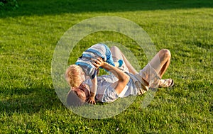 Happy father and son having fun outdoor on meadow