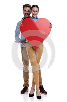 Happy couple holding a big red heart