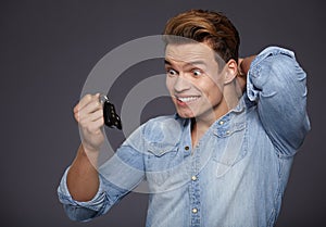 Happy men holding out car keys.