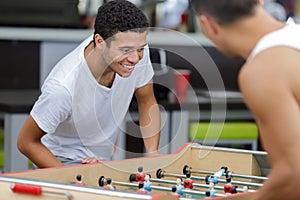 happy men playing football table