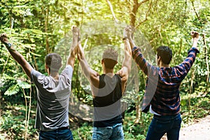 Happy men traveler friends hands raise up together at nature,Enjoying backpacking concept,Back view