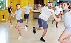 Happy men and women enjoying active dance