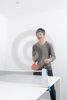 Happy mid adult man playing ping pong