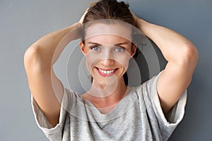 Happy mid adult woman smiling with hands in hair
