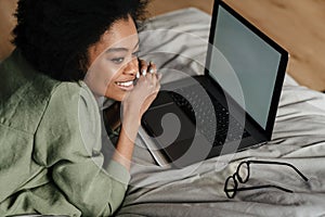 Happy young african woman using laptop computer