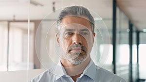 Happy mid aged older business man standing in office. Headshot portrait