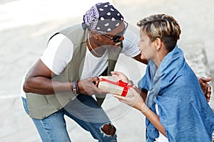 Happy middle age interracial couple sitting . Man giving Valentine& x27;s day gift to his woman,girlfriend or wife