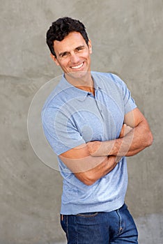 Happy middle age man smiling with arms crossed