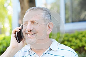 Happy middle age man talking on the phone