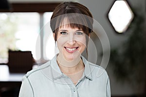 Happy middle age woman smiling at the camera. She is working at home